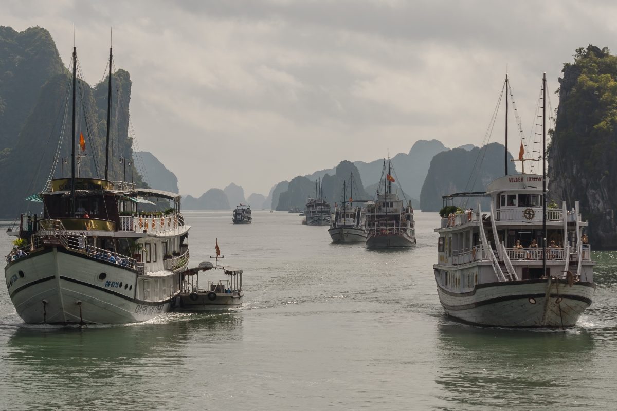 Cruise boats sailing among limestone islands in Ha Long Bay