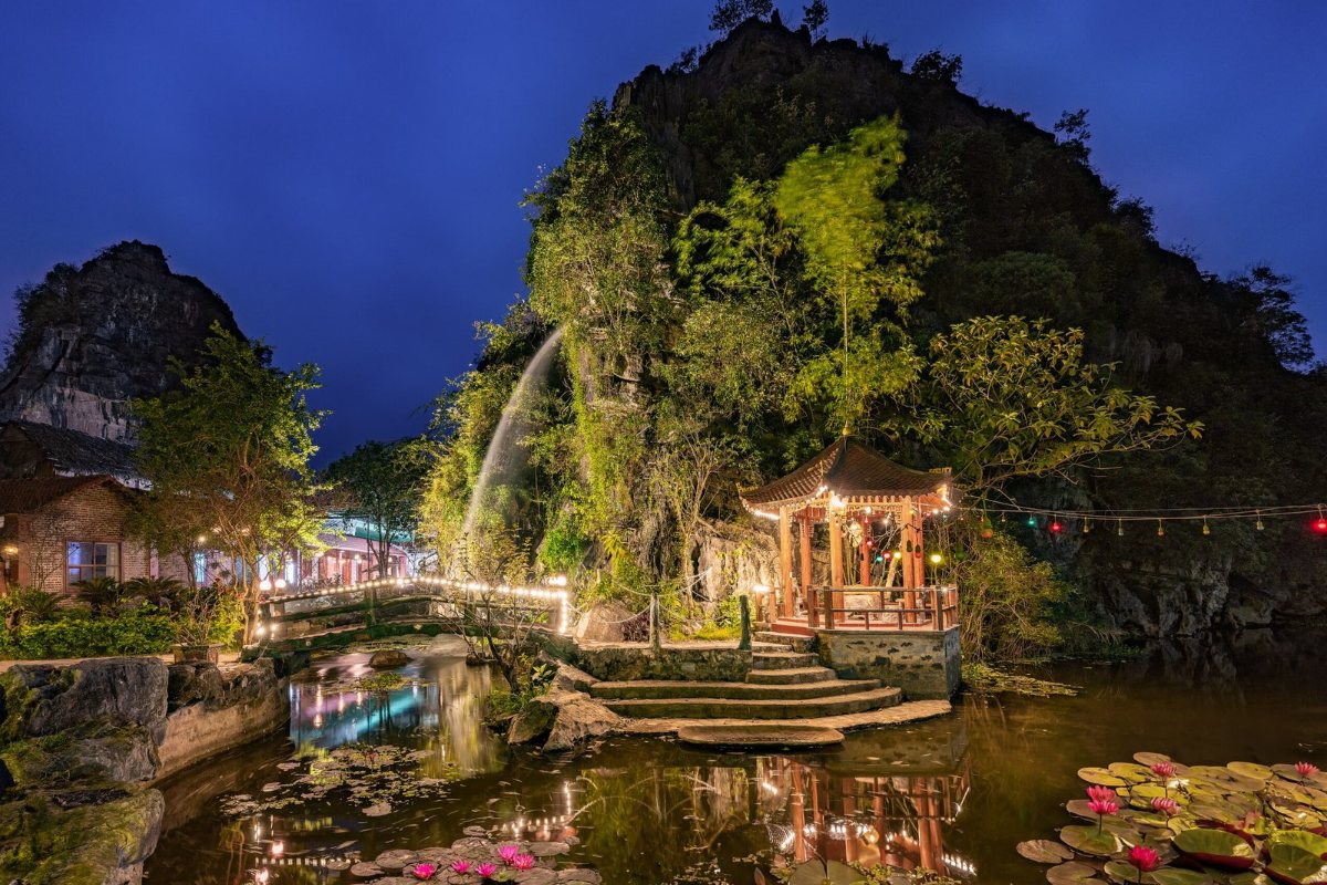Lake and limestone mountain at night at Trang An Heritage Garden